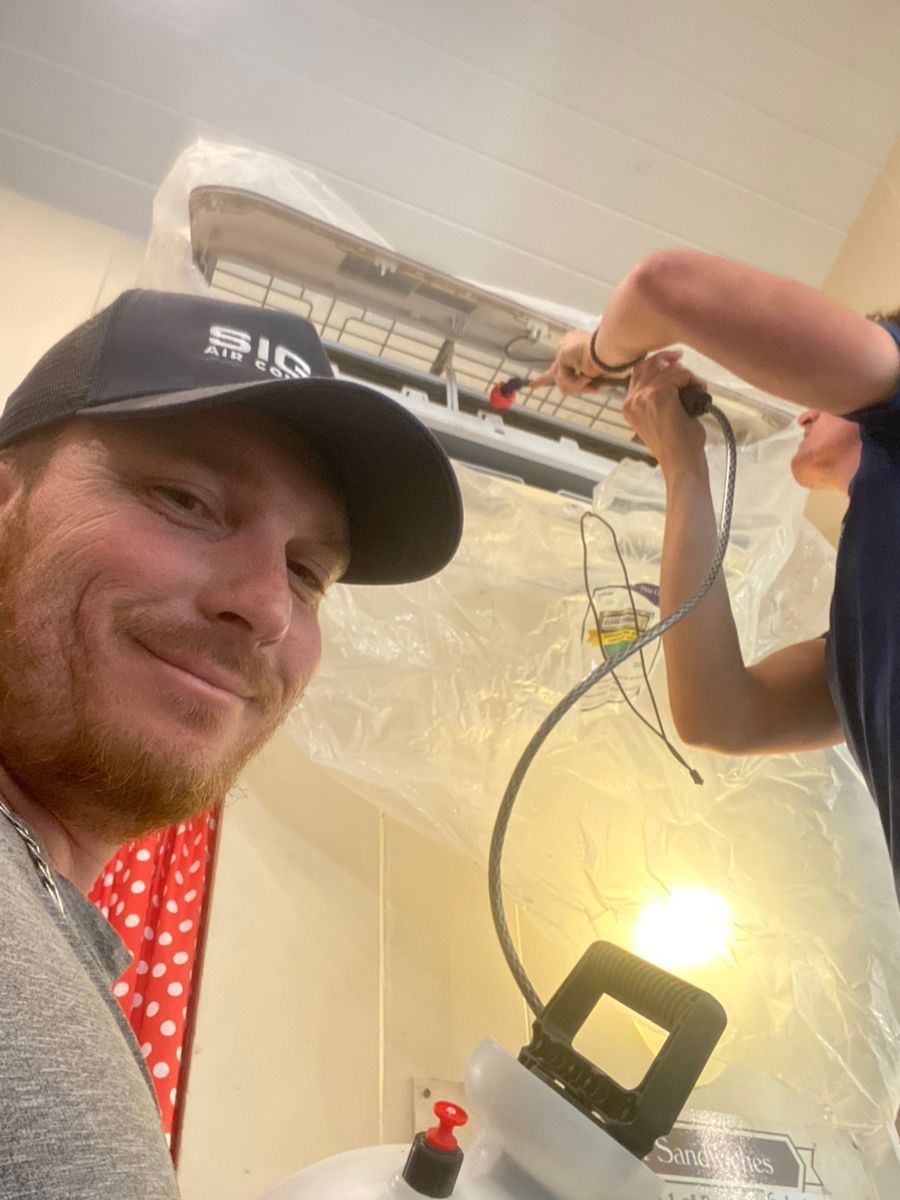 Siggs technicians cleaning minisplit