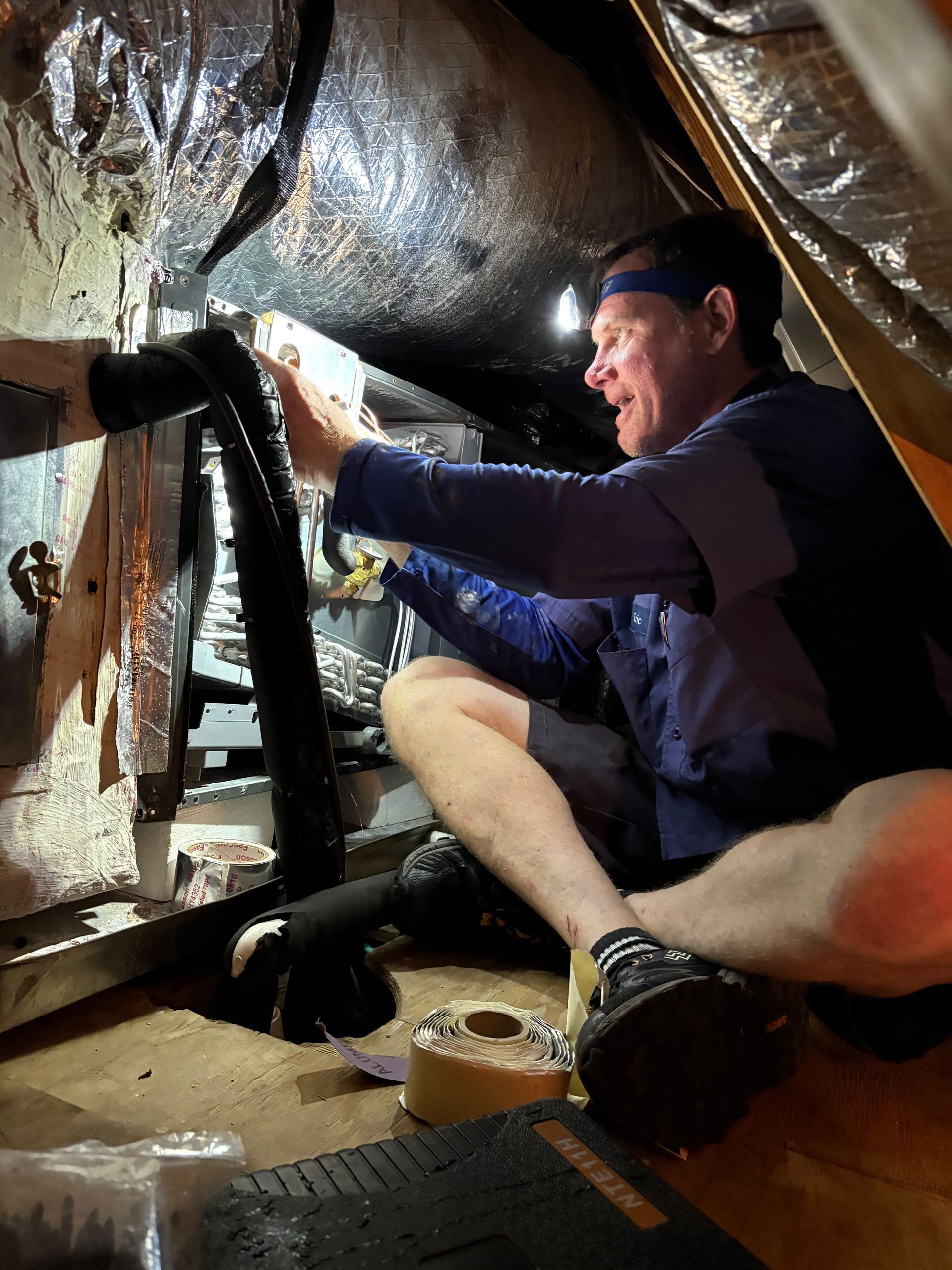 Siggs technician servicing indoor attic air handling unit AHU