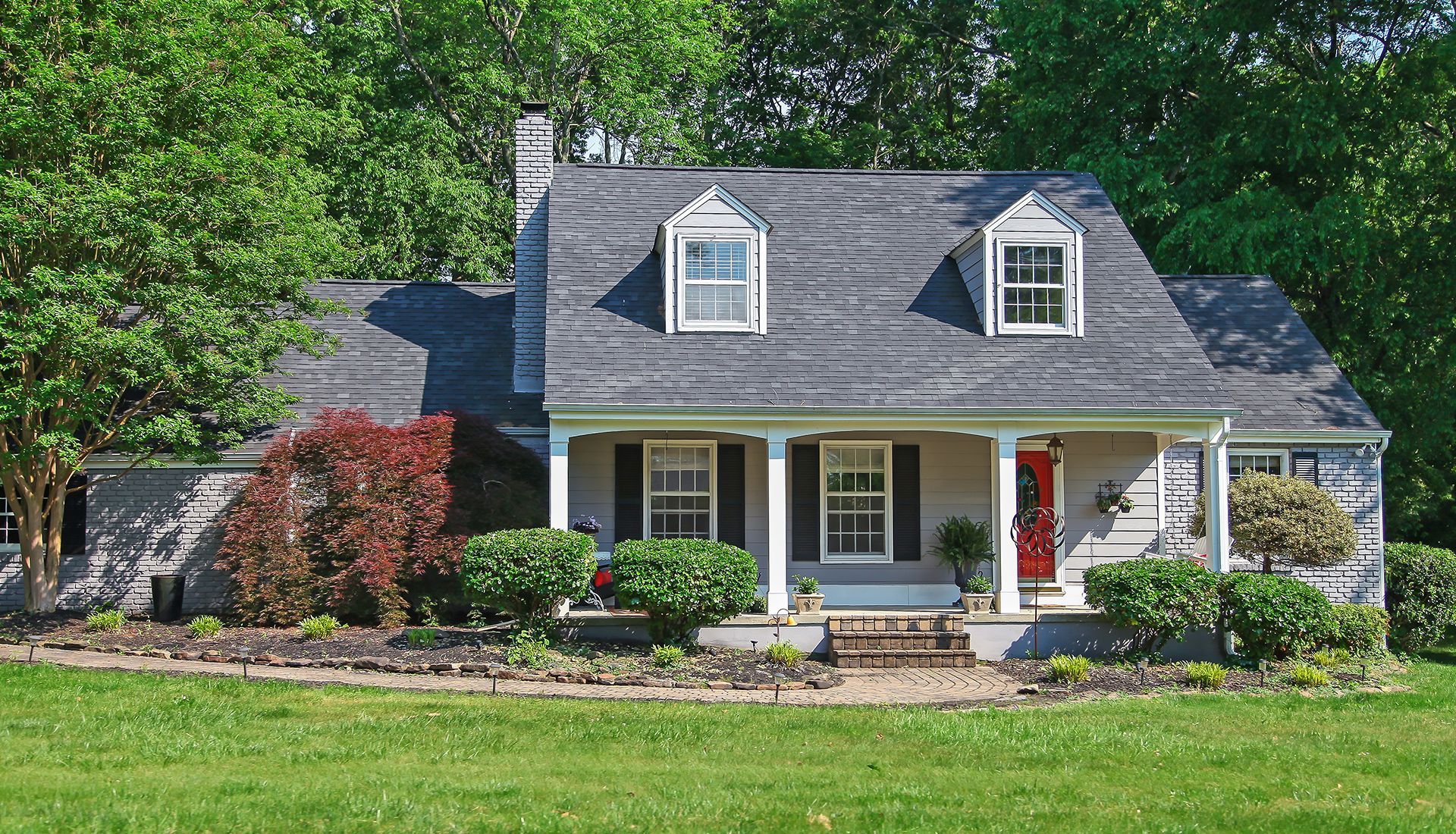 Modern dining room with glass table, white chairs, and sliding doors to the patio.