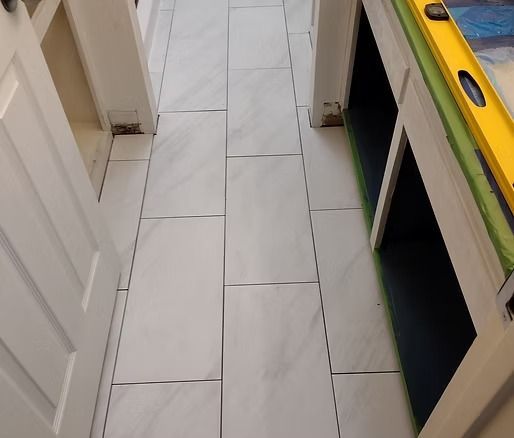 White tiled floor between cabinets. A level rests on a counter.