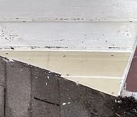 White painted wood siding, tan trim, and dark asphalt shingle roof.