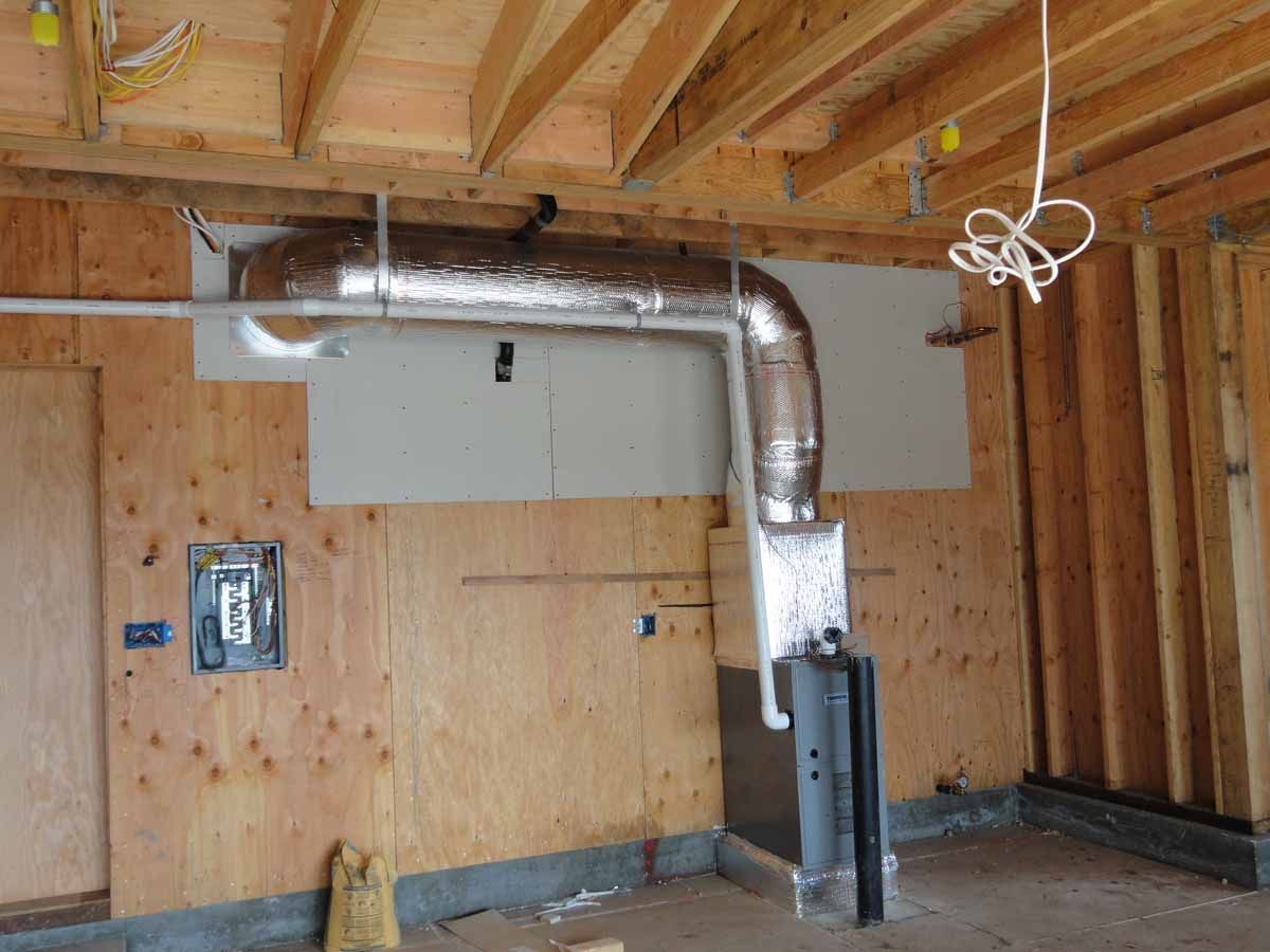 A room with wooden walls and a metal pipe hanging from the ceiling.