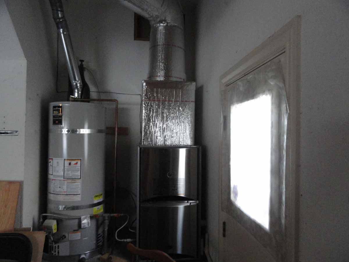 A water heater in a room next to a window