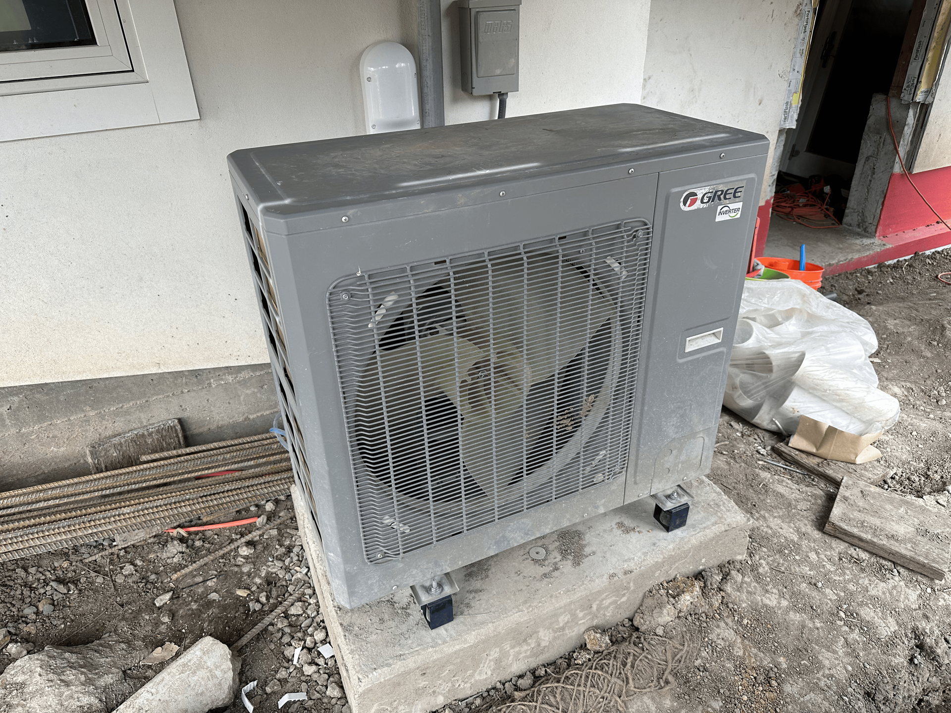 A large air conditioner is sitting on top of a concrete block.