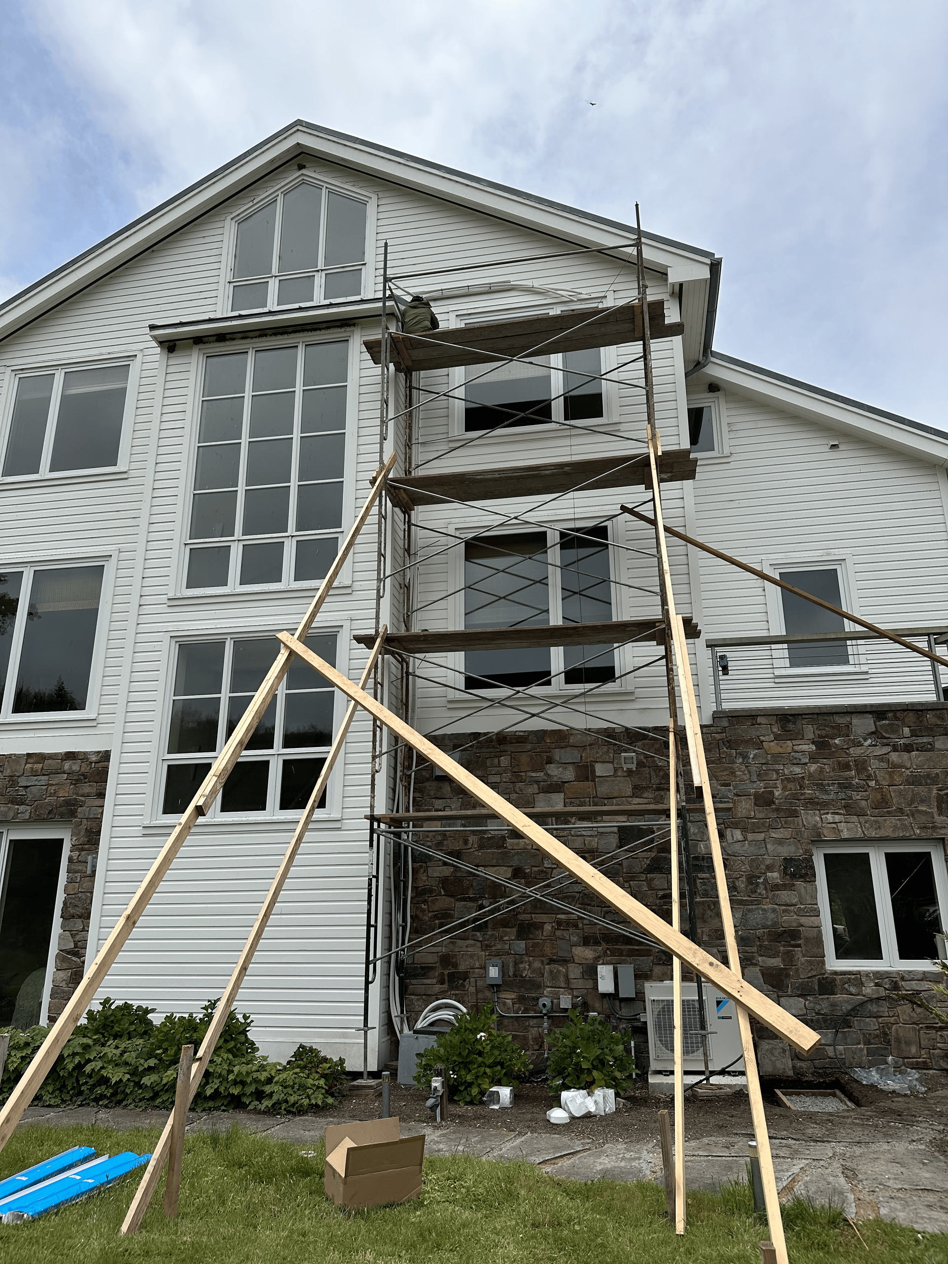 A large white house with scaffolding in front of it.