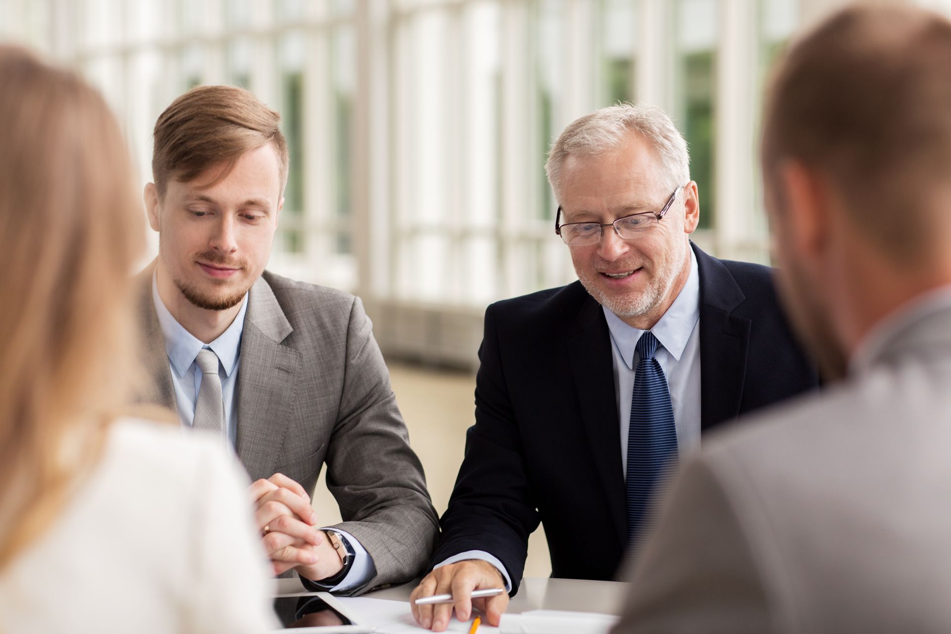 A group of business people are sitting around a table having a meeting.