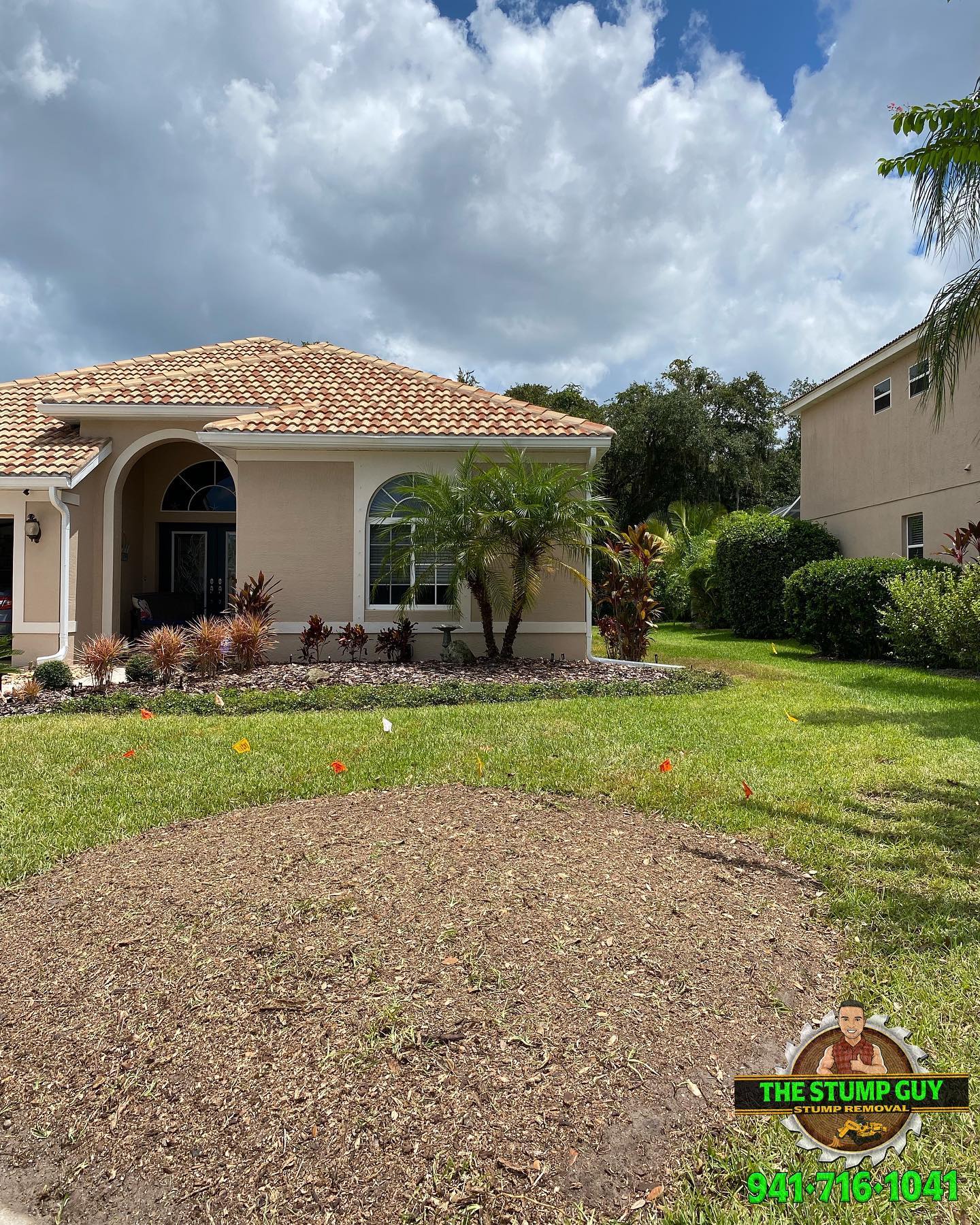 House with beige exterior, tiled roof, and landscaped yard; cloudy sky.