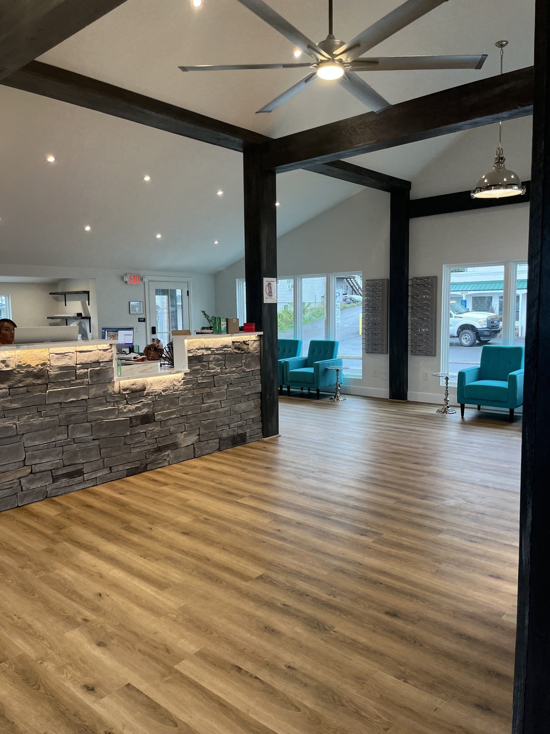 A large room with wooden floors and a ceiling fan