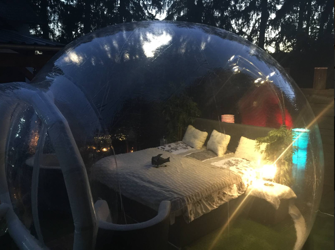 Ein Bett steht nachts in einer Bubble.