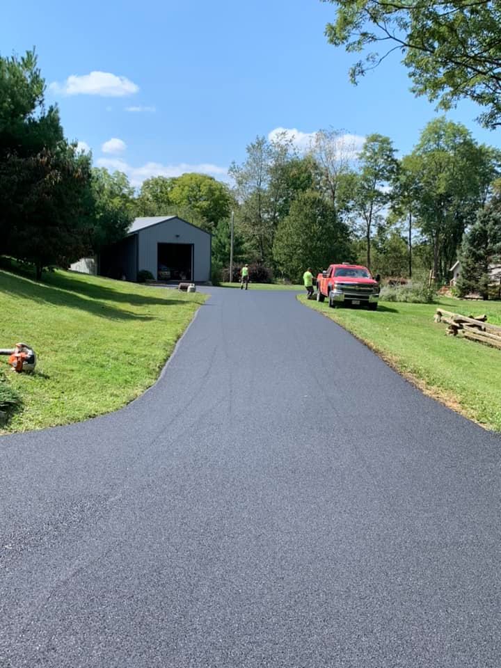 Asphalt Installation Projects — Asphalt Road with a Red Car in Zanesville, OH