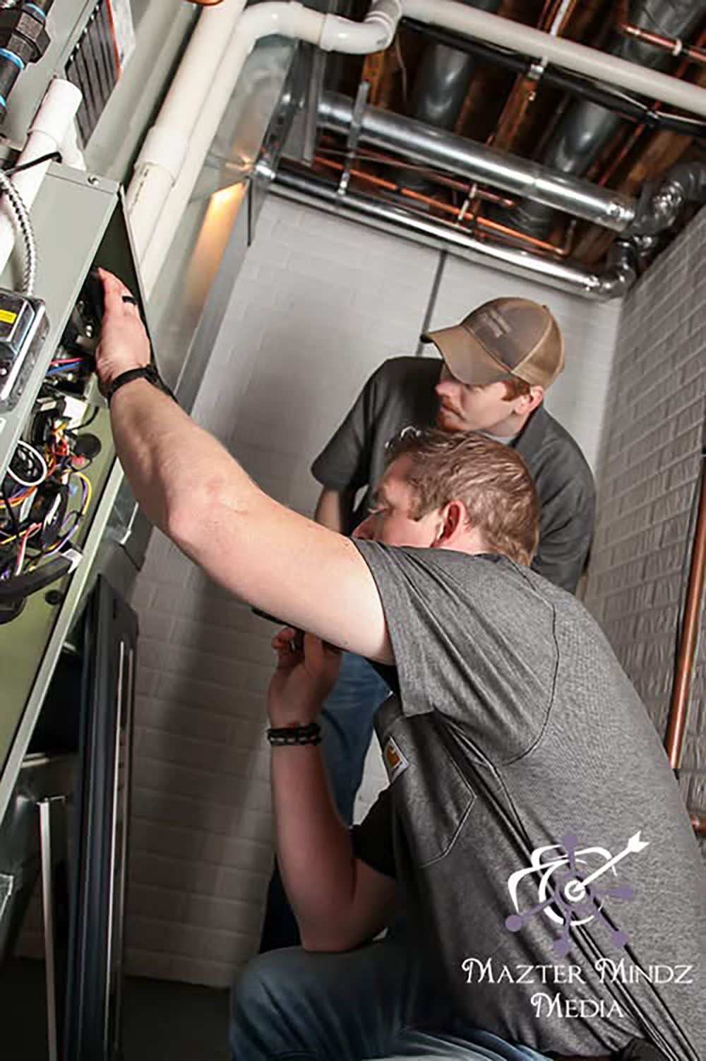 HVAC techs checking on a furnace