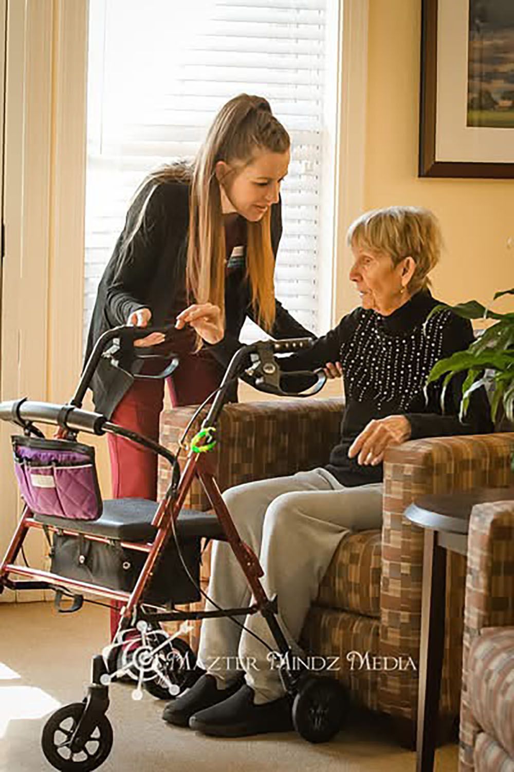 Assisted living nurse helping a woman to her walker