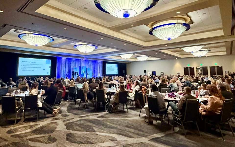 a conference room full of people sitting at tables