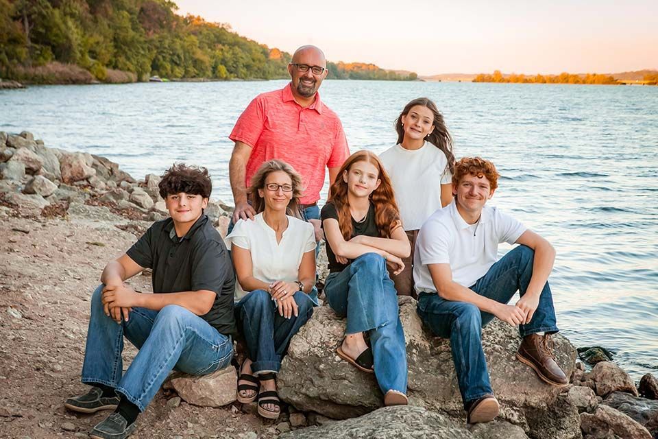 Family sitting by lake by Mazter Mindz Media Bloomington IL Photographer