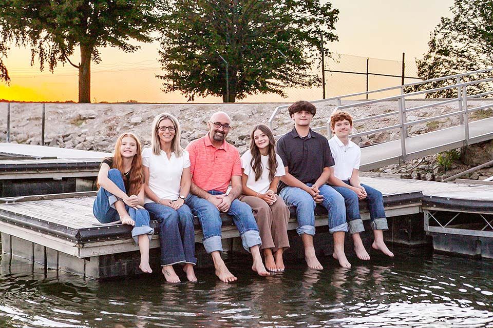 Family sitting on a dock by Mazter Mindz Media Bloomington IL Photographer