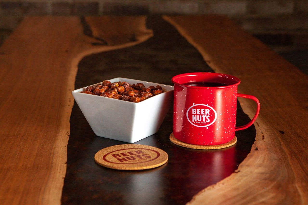 Nuts in a bowl next to a coffee cup