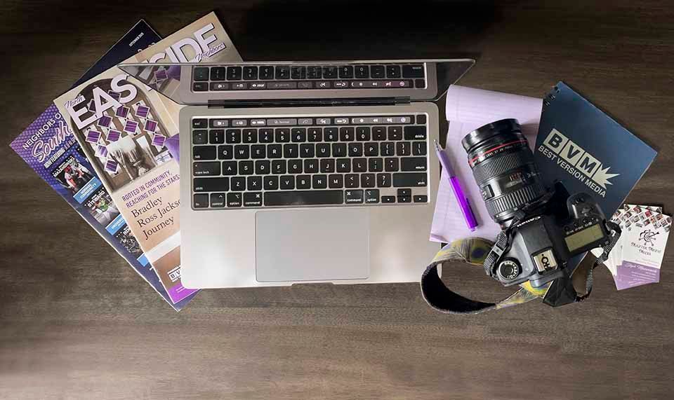 Overhead view of magazines, computer and camera