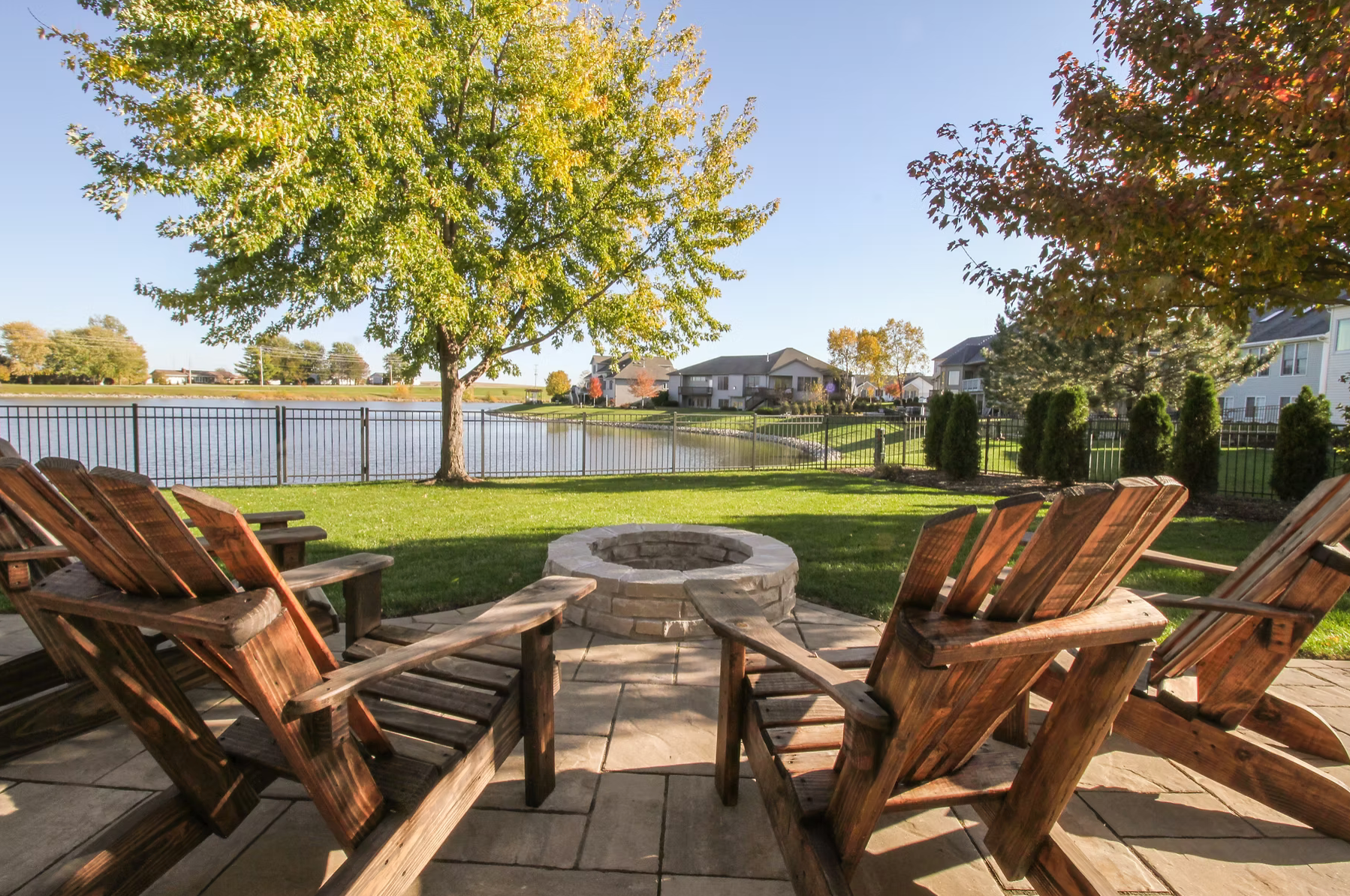 view from back of chairs looking at firepit by the pond