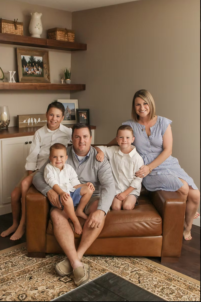 family of 5 sitting on a chair smiling