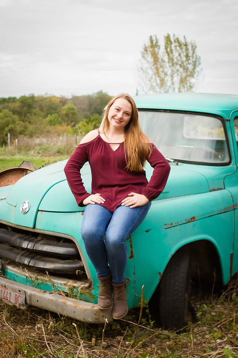 senior girl sitting on a turquoise old fashion truck