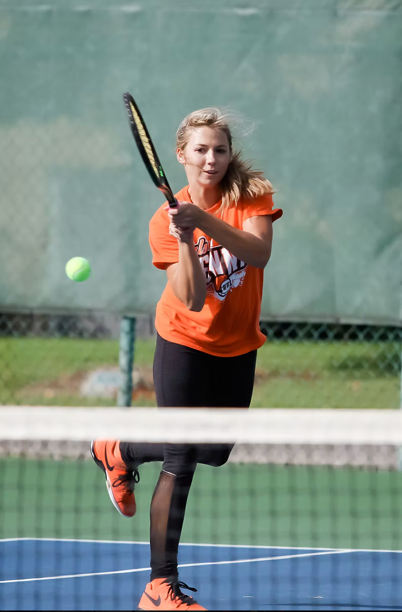 tennis player hitting ball over the net