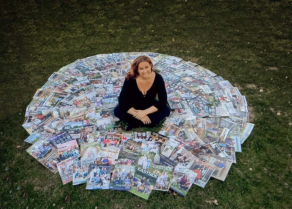 Woman sitting inside a circle of magazines smiling