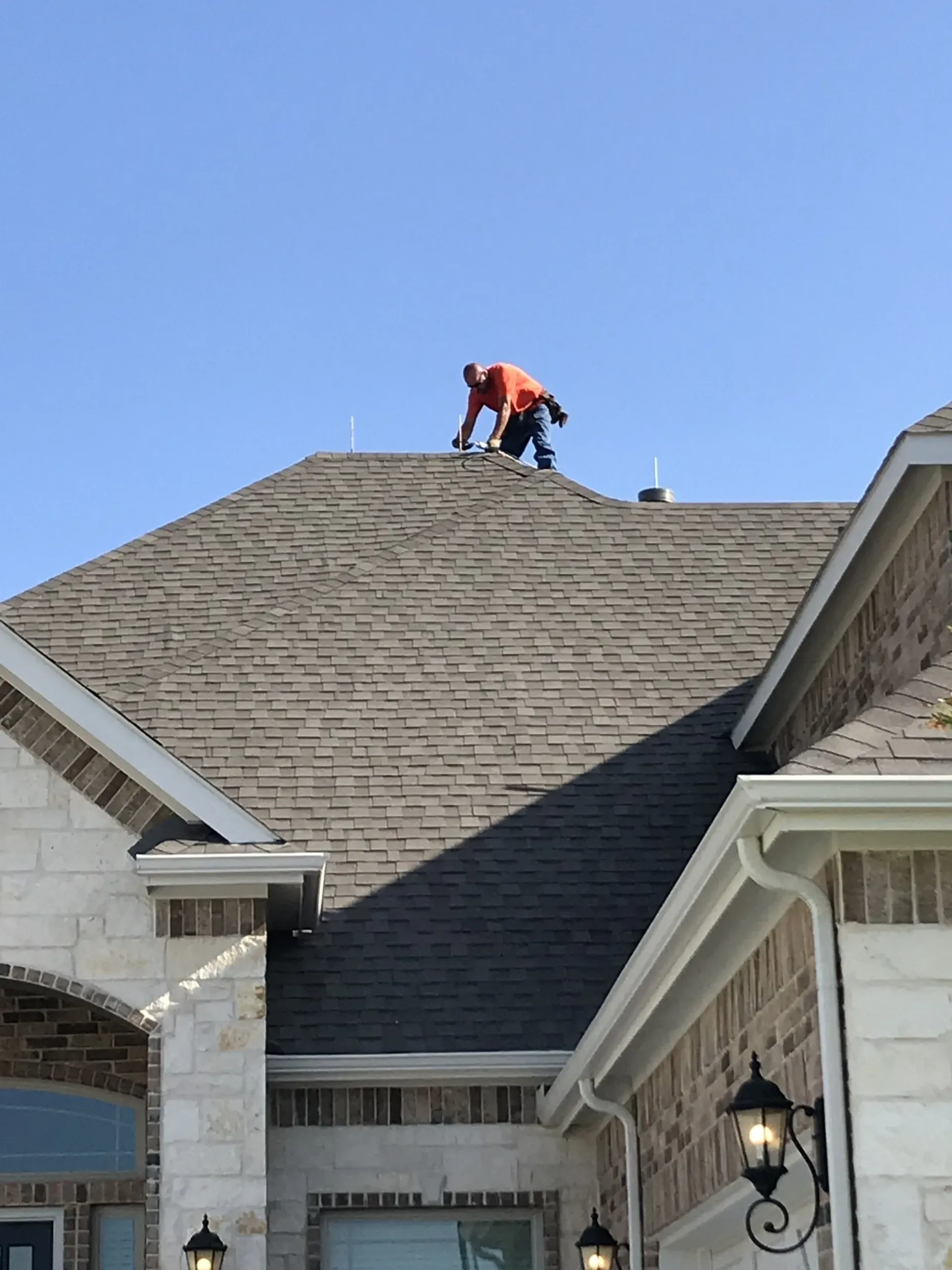 A man is working on the roof of a house