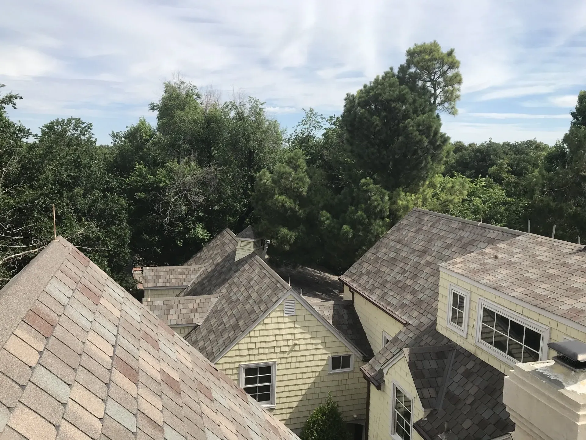 A rooftop view of a house with trees in the background