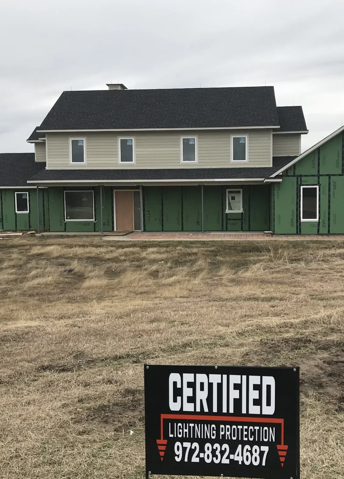 A certified lightning protection sign in front of a house