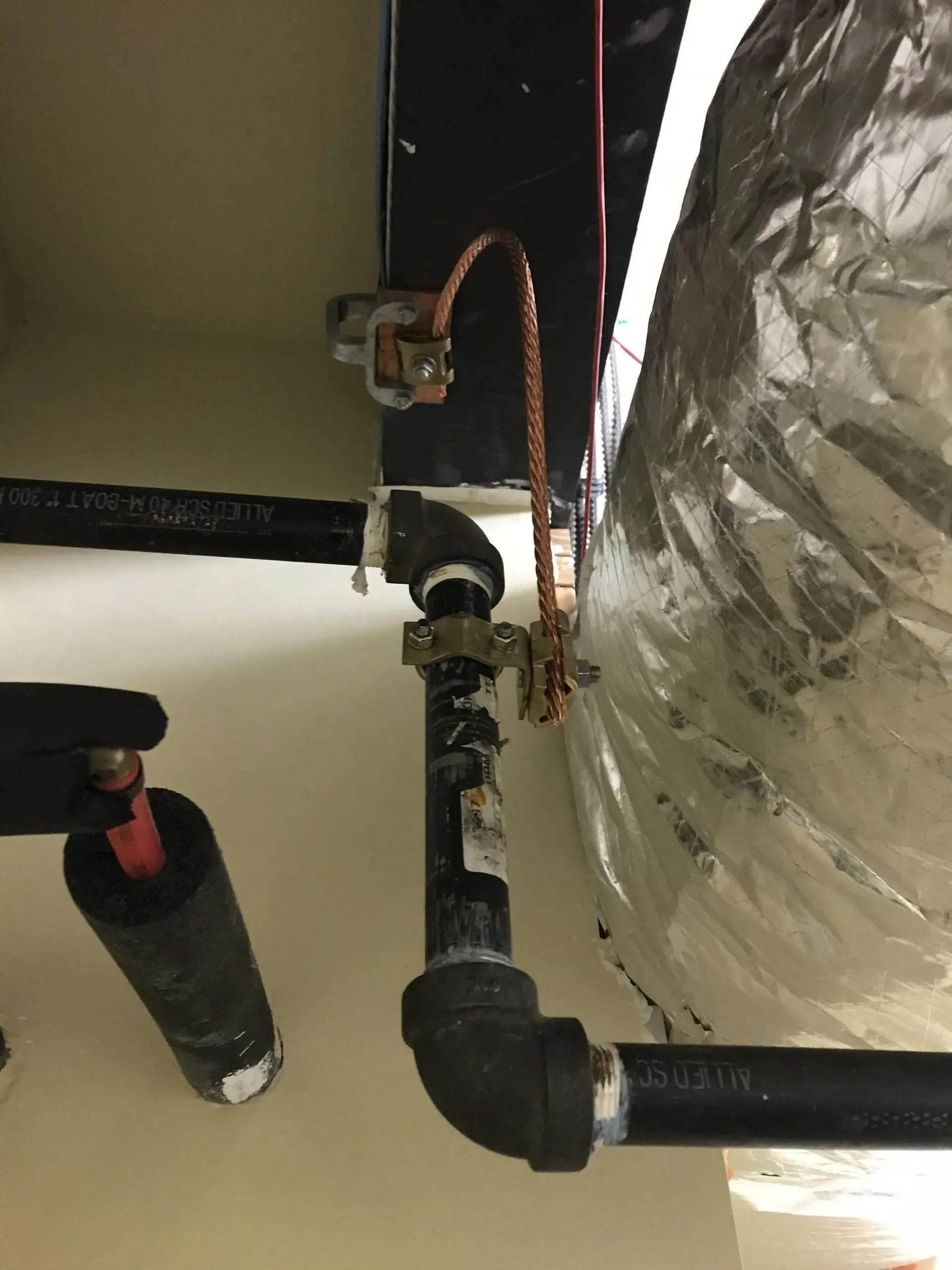 A close up of a pipe with a copper wire attached to it