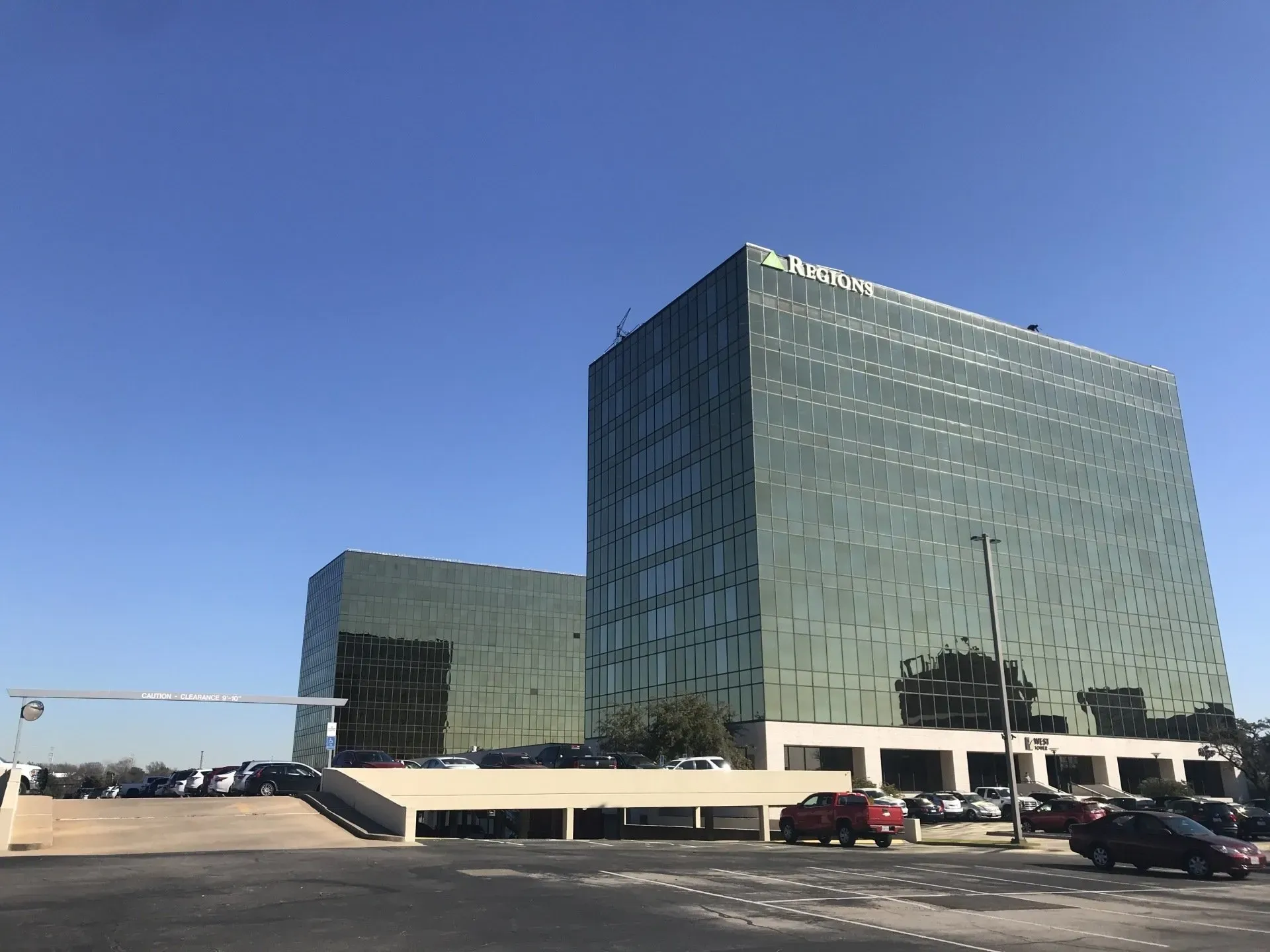 A large building with a lot of windows and cars parked in front of it.