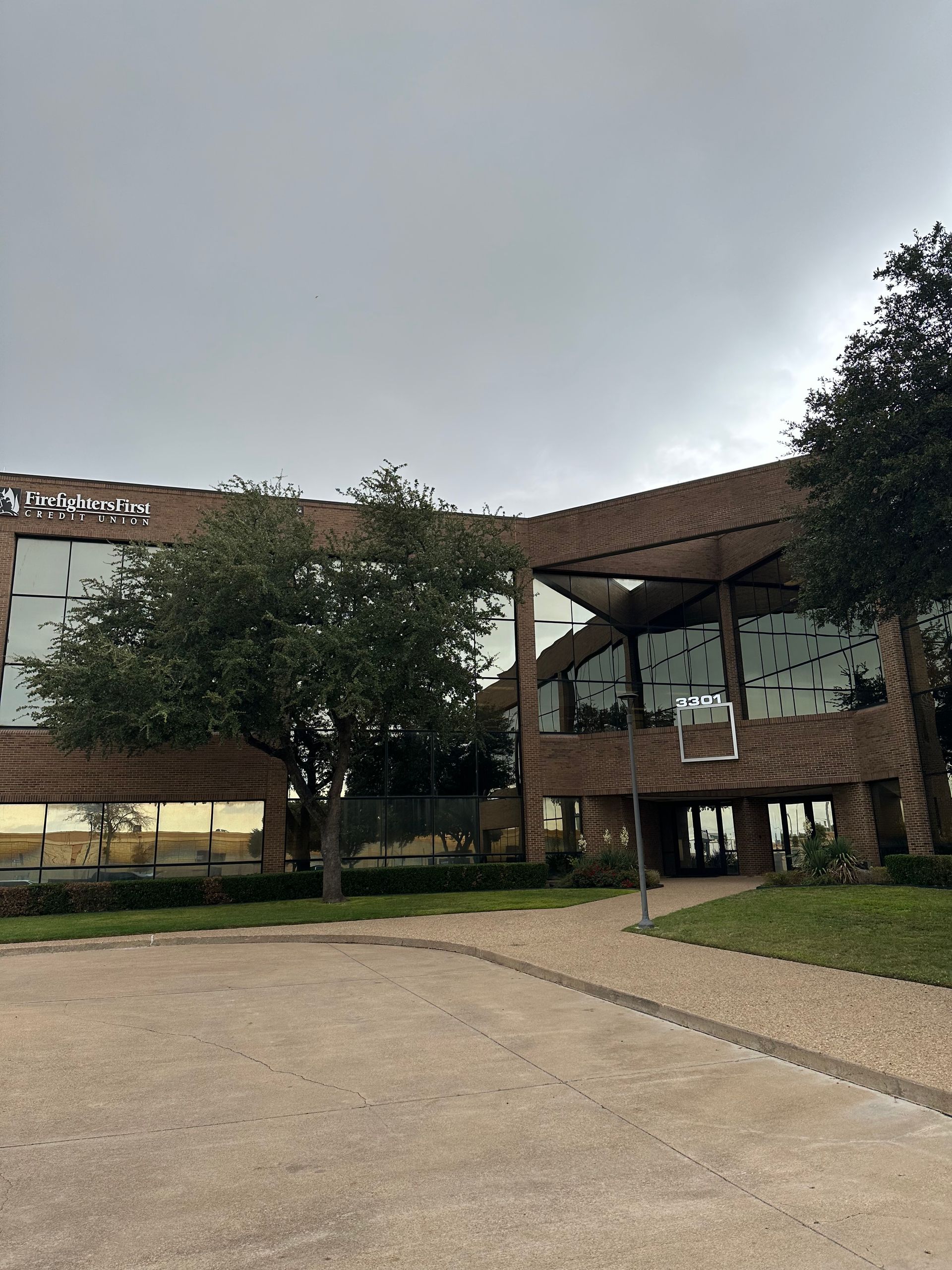 A large building with a lot of windows and trees in front of it