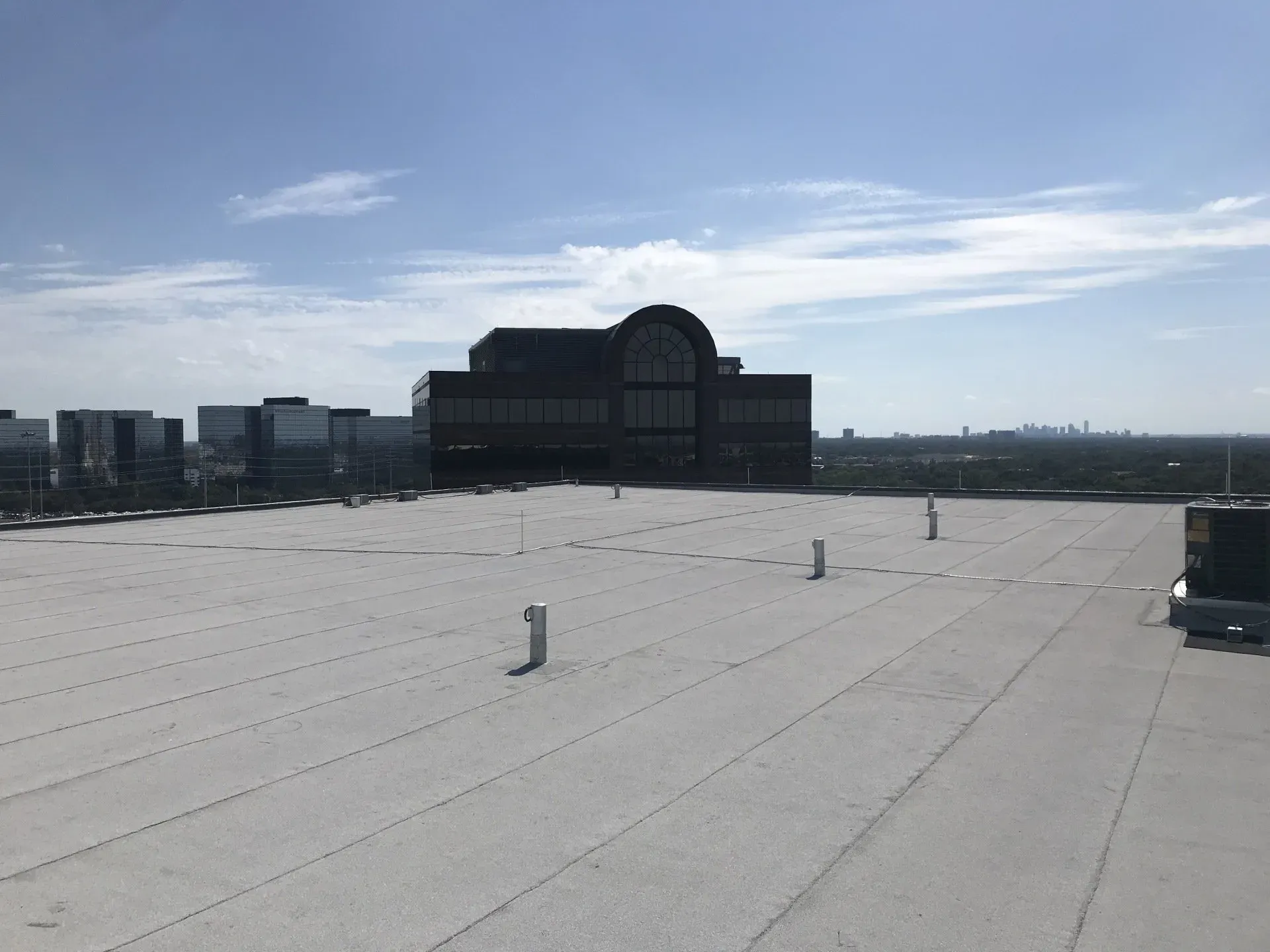The roof of a building with a large building in the background.