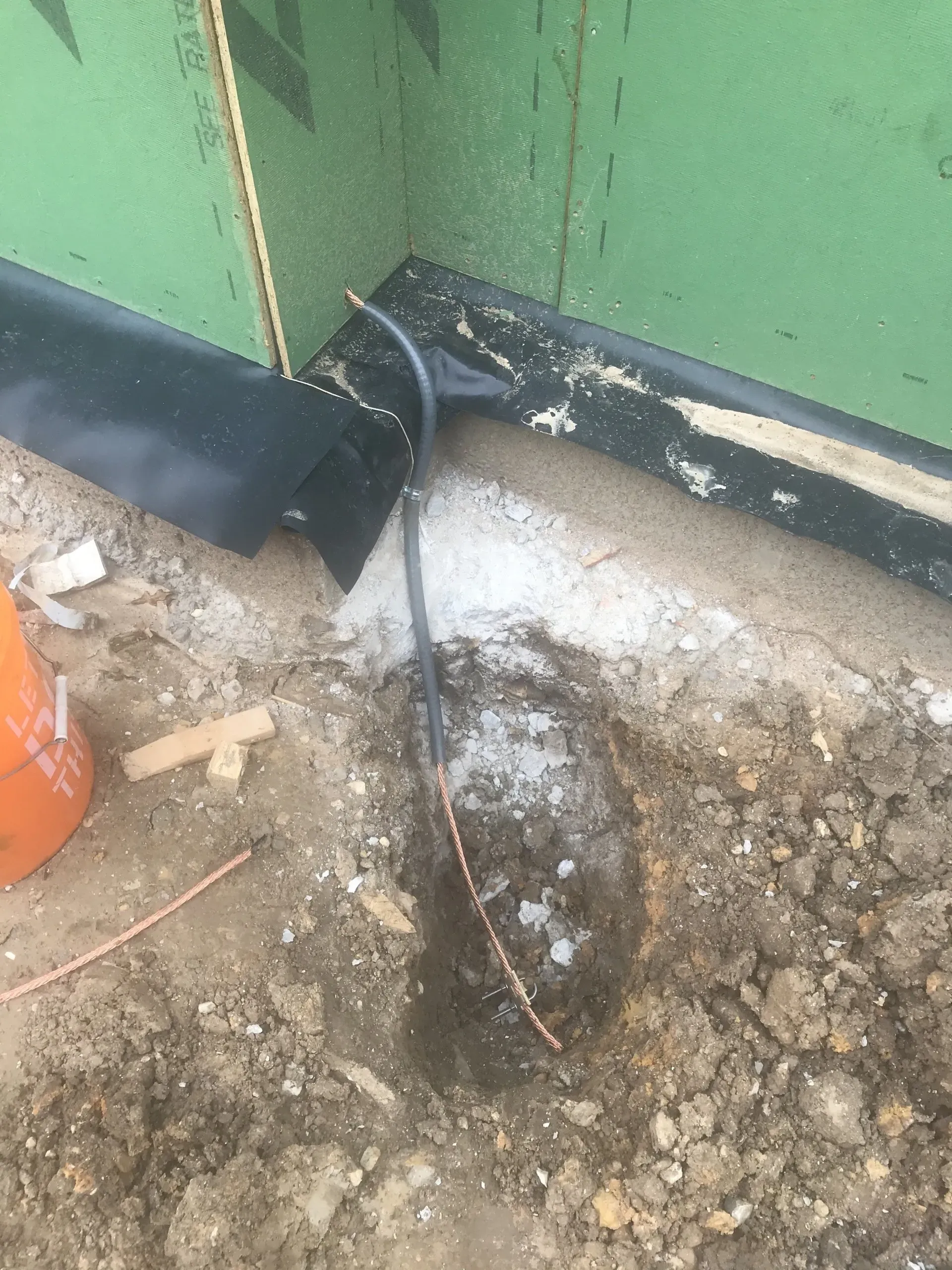 A hole in the ground with a wire sticking out of it.