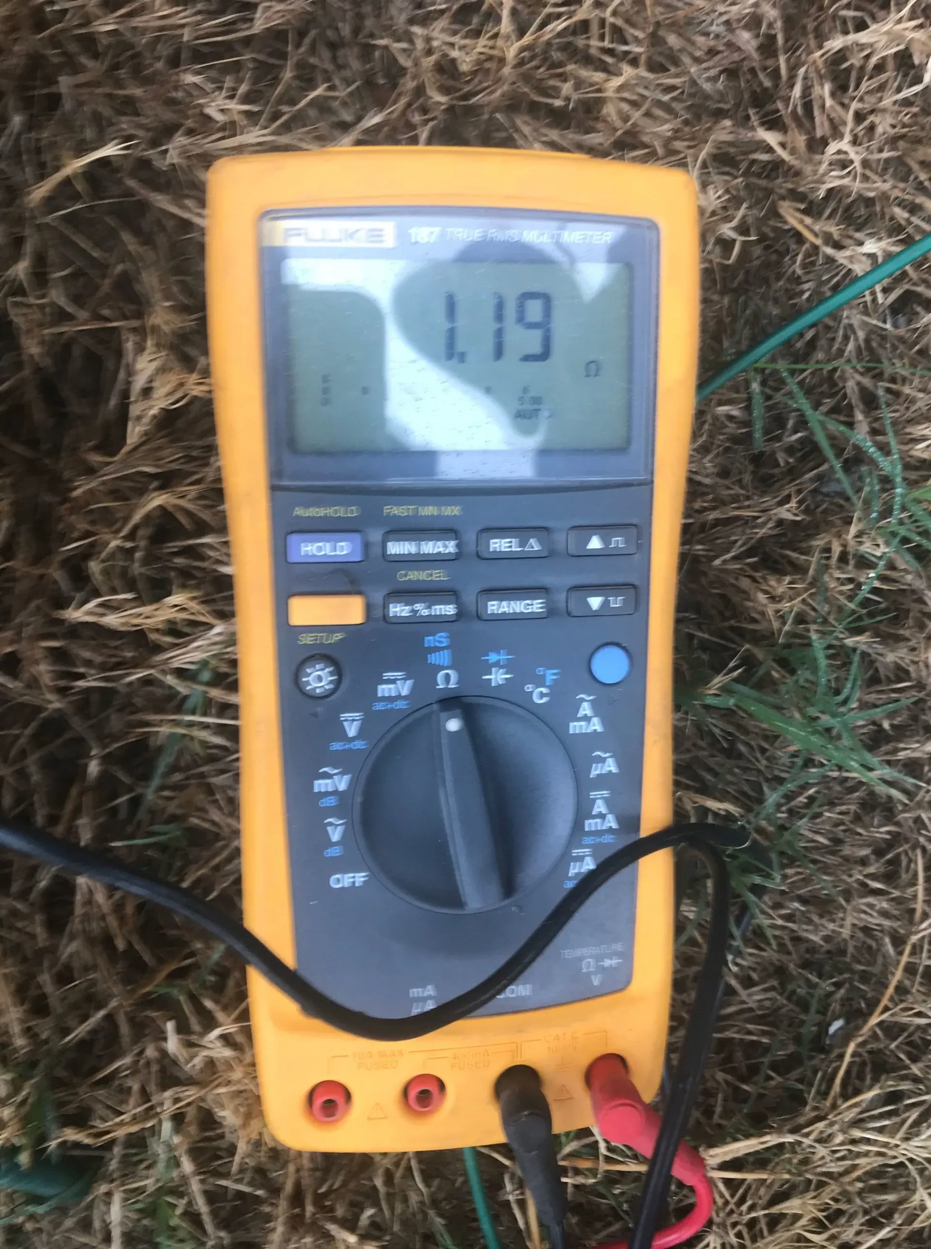 A fluke digital multimeter is sitting in the grass