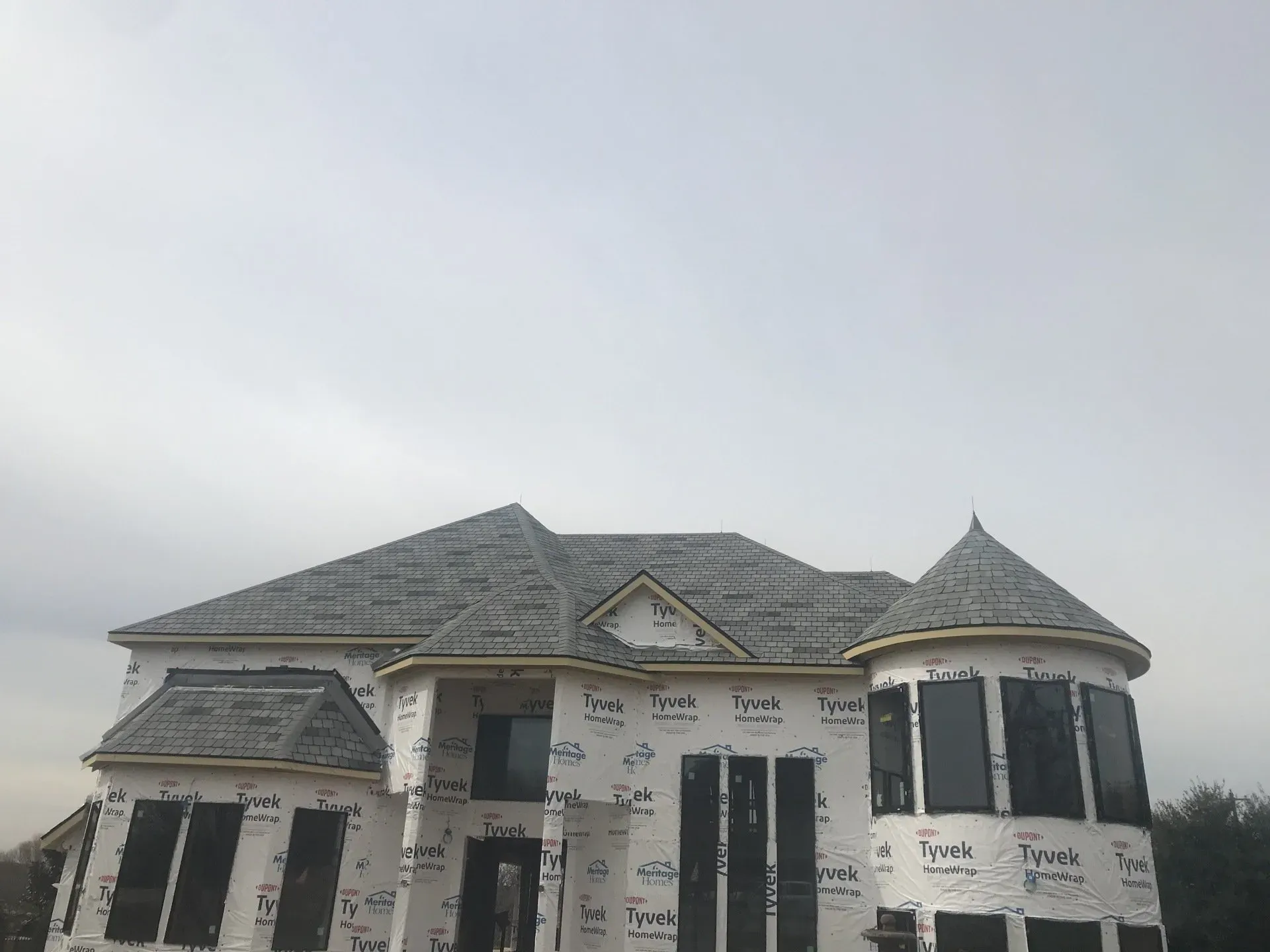 A large house under construction with a gray roof