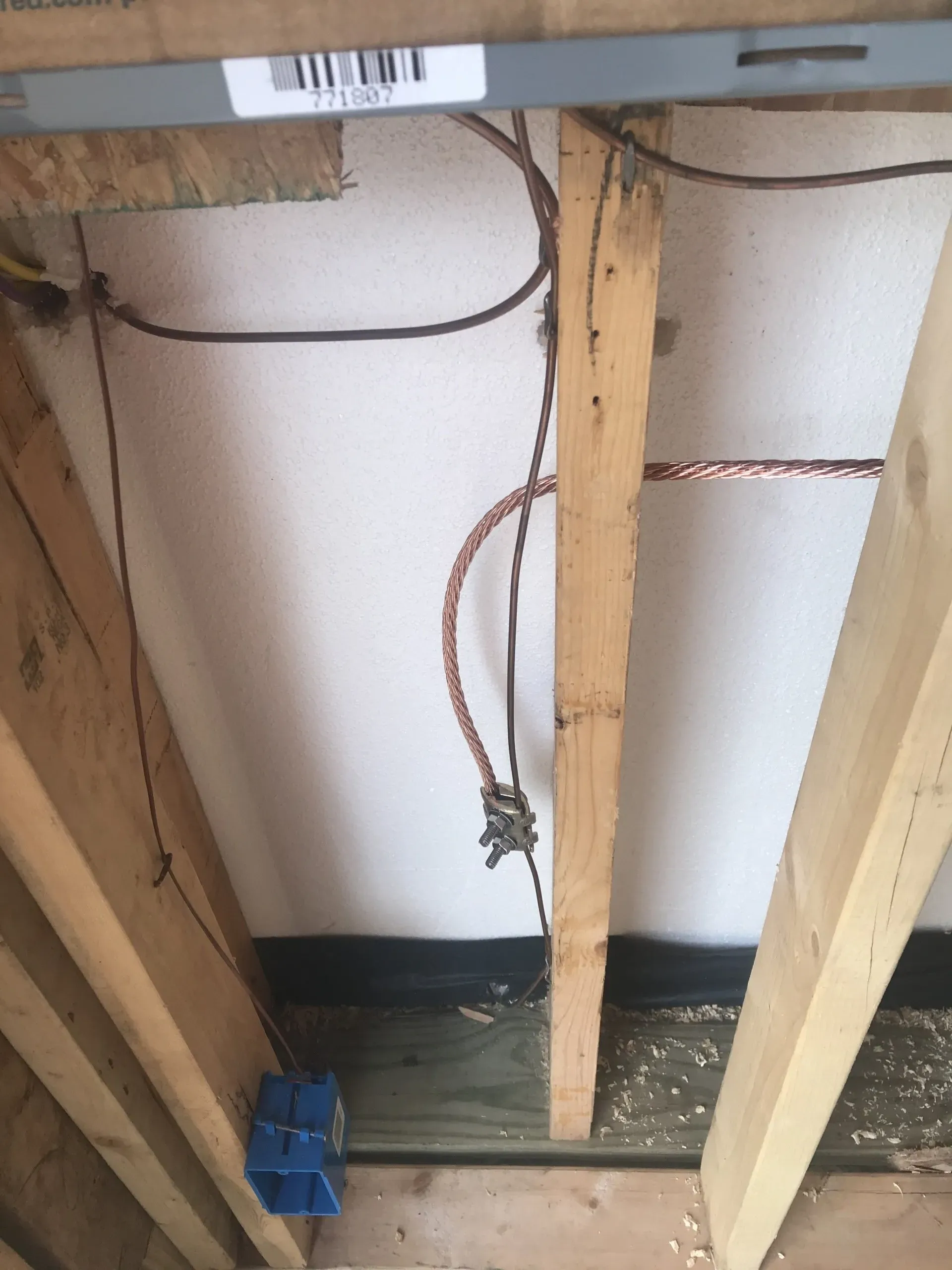 A bunch of wires are hanging from the ceiling of a building