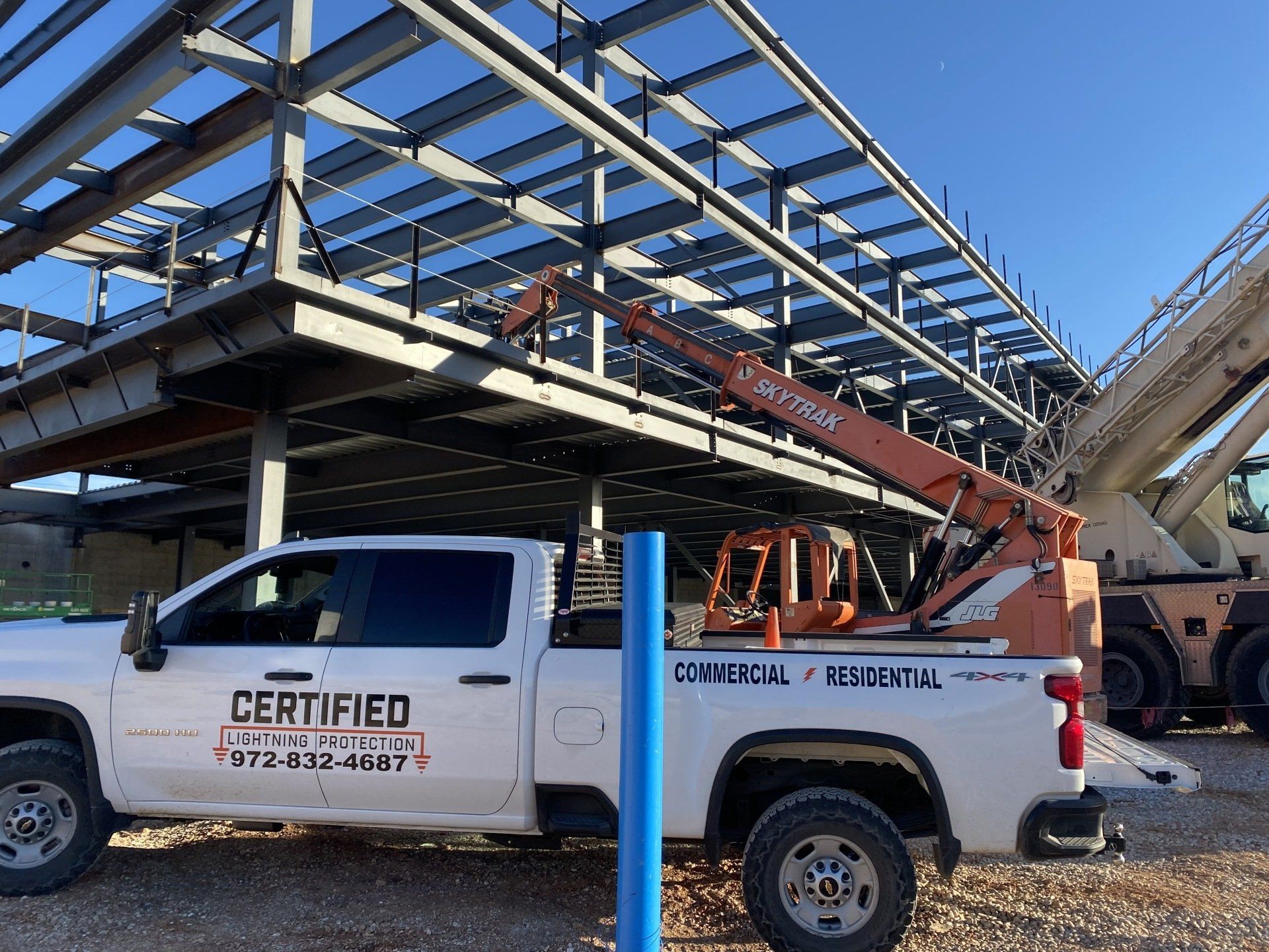 A certified truck is parked in front of a building under construction