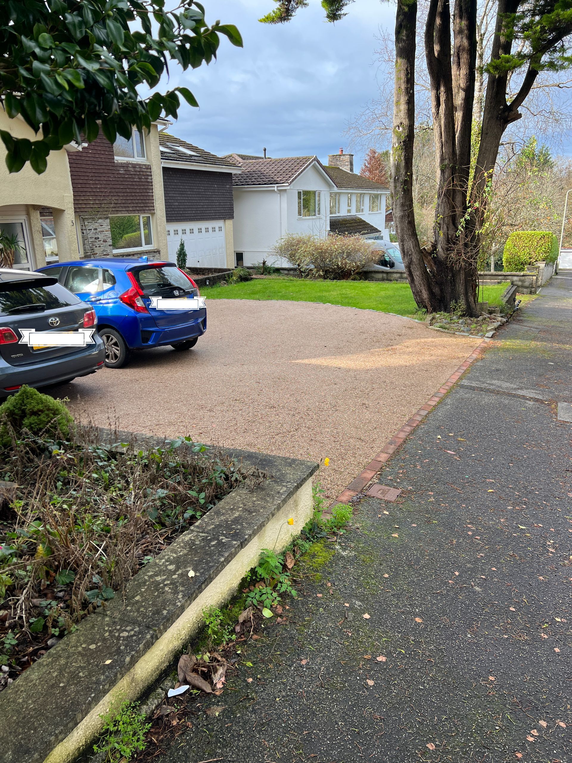 Beige resin driveway with 2 cars parked on top