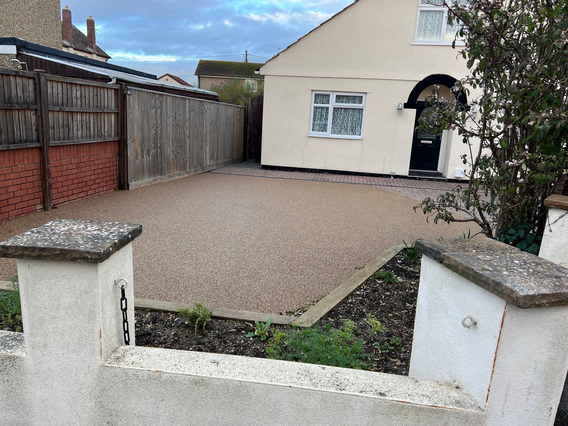 Brown resin driveway outside beige bungalow