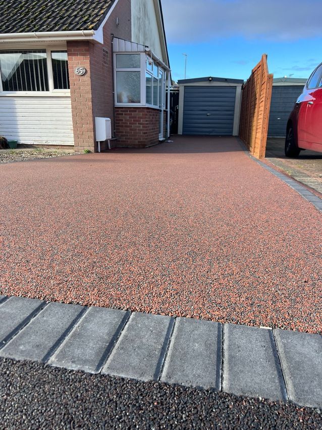 Red resin driveway with grey block paving border