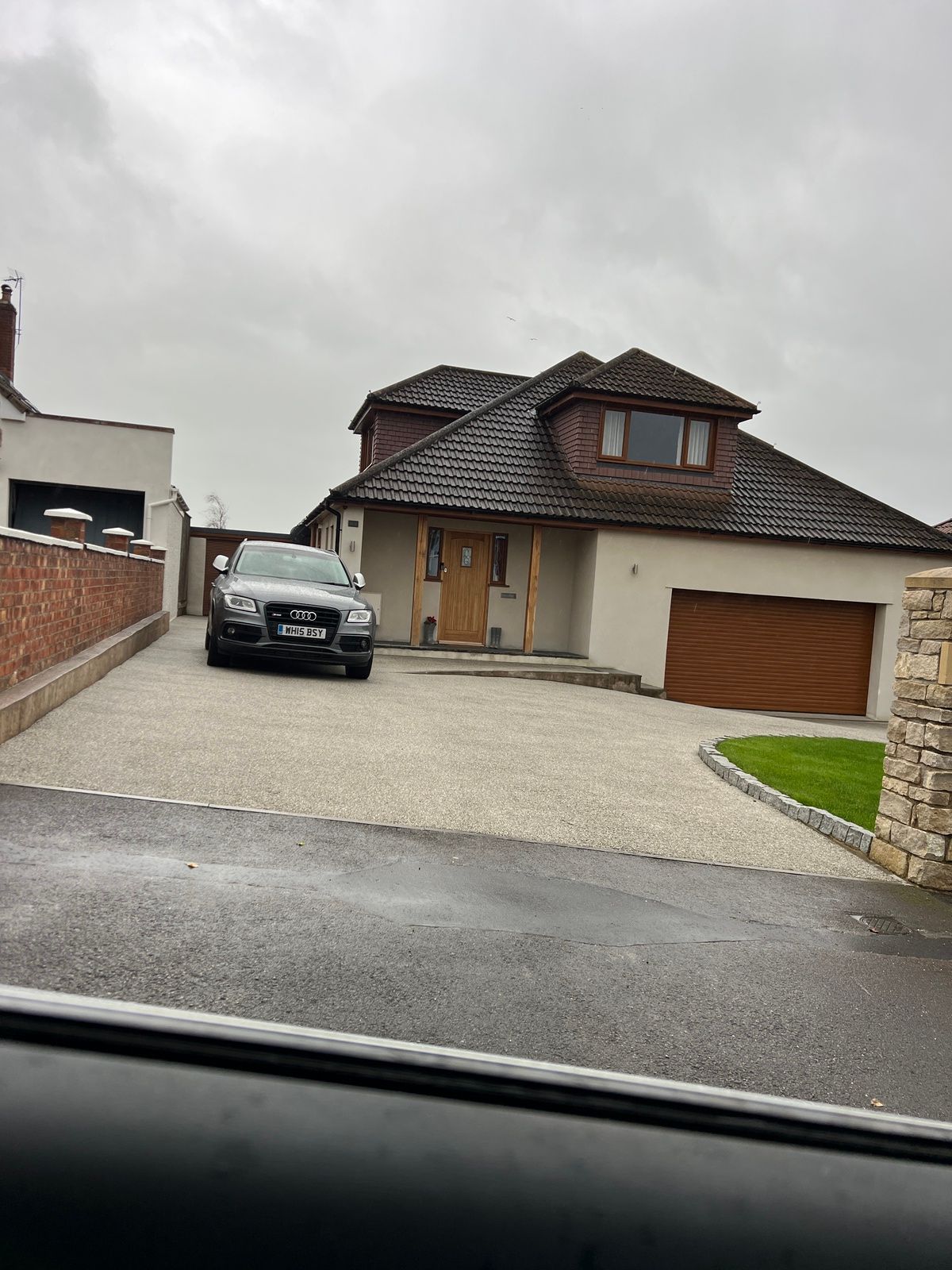 Beige resin driveway with grey car parked on top