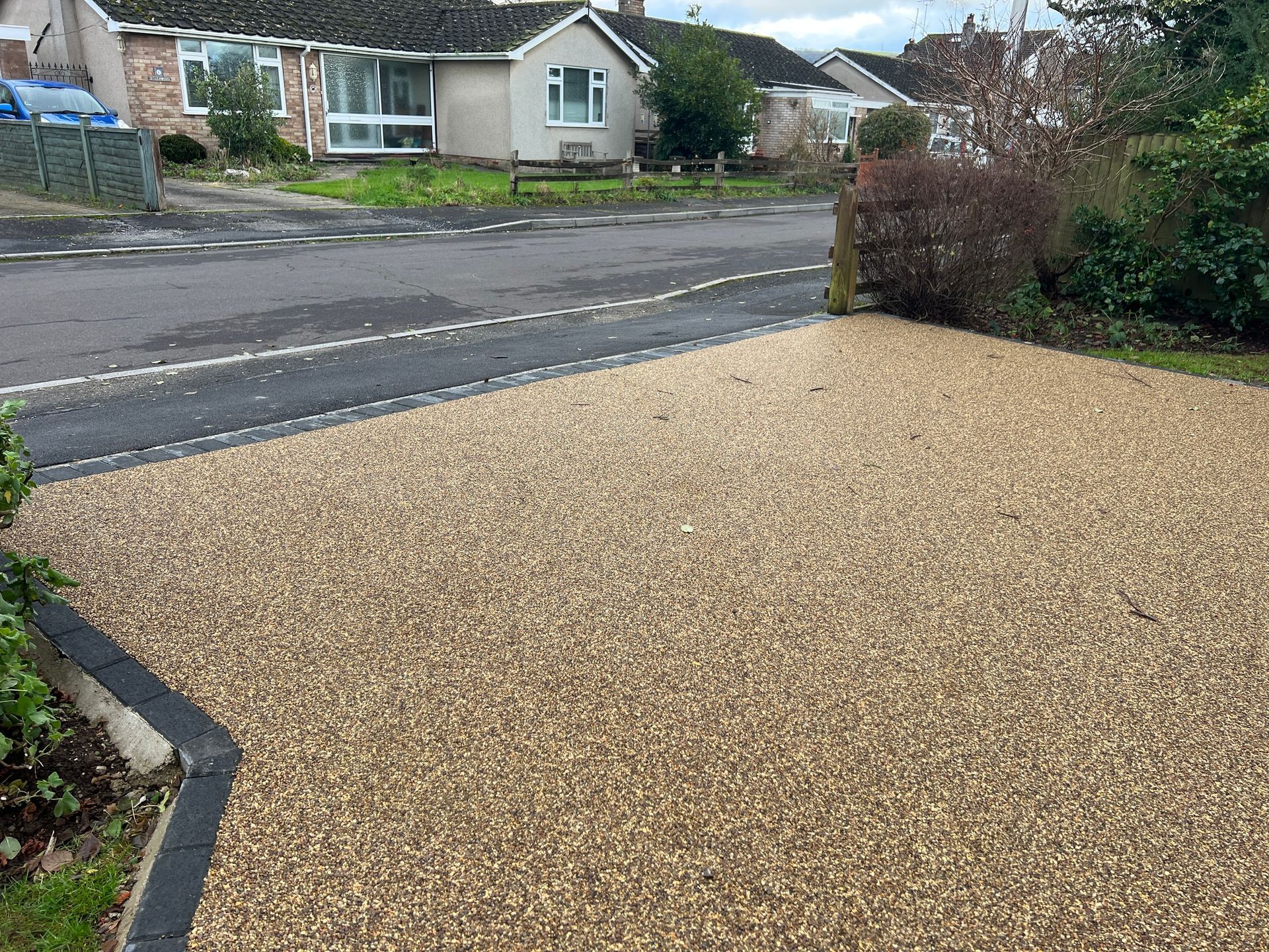 Beige resin driveway with the main road in sight