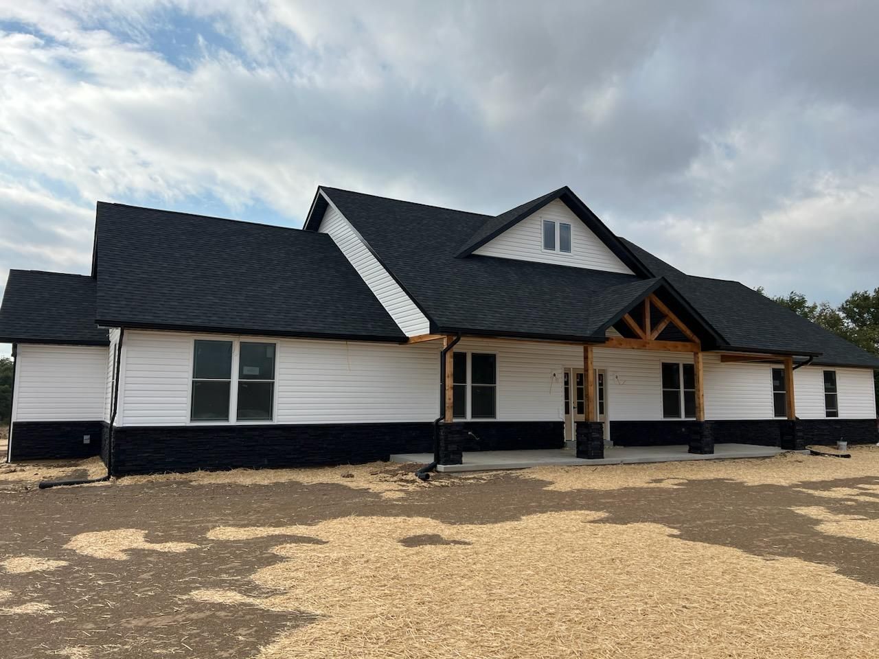 a large white and black house with a black roof - — Perry, MO — Grossmann Masonry, LLC