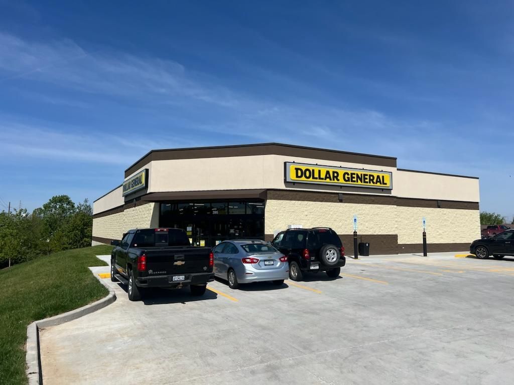 A dollar general store with cars parked in front of it.
