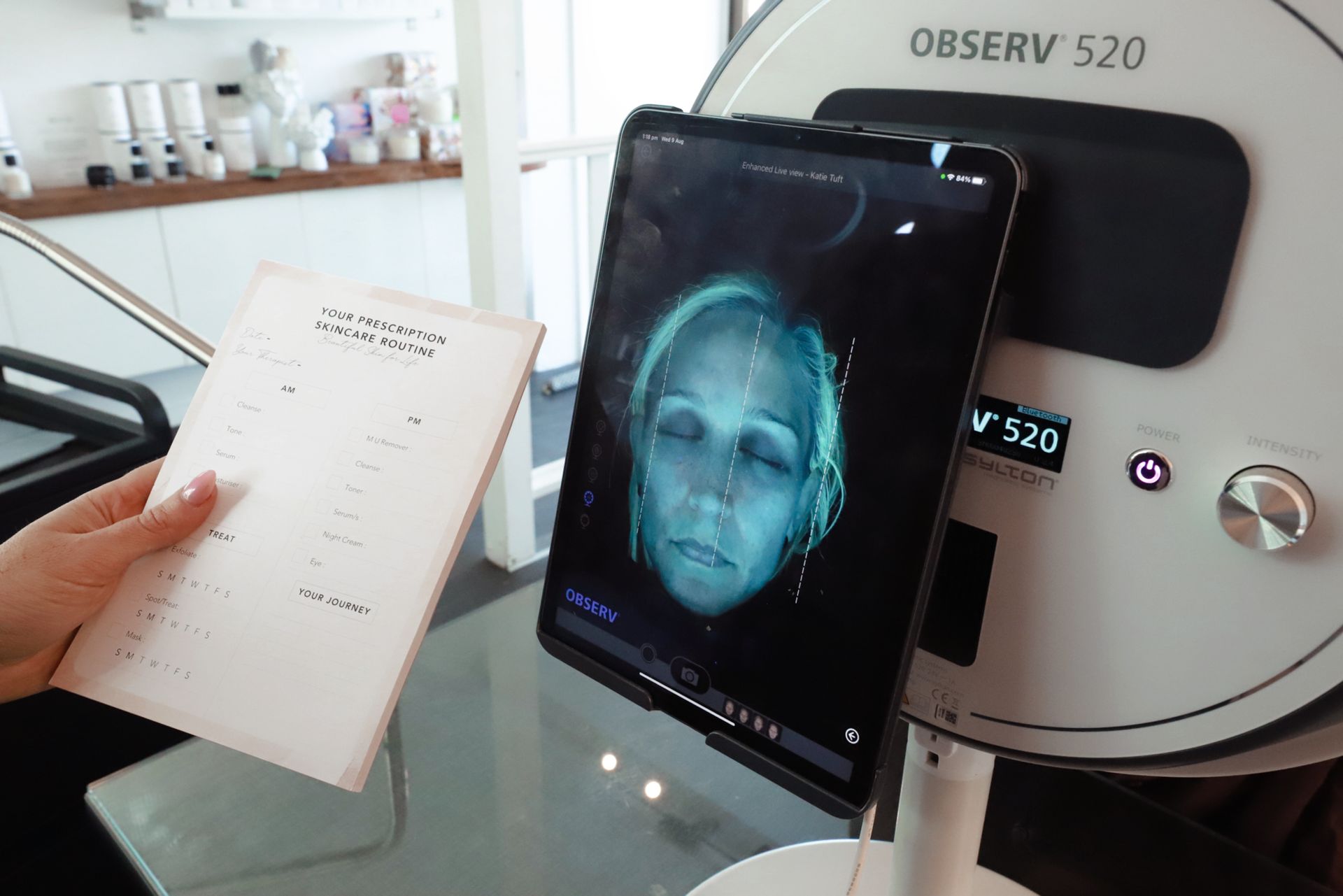 A Person Holding a Paper Sheet Next to a Facial Analysis Device — Vanity Skin and Beauty Forster in Forster, NSW
