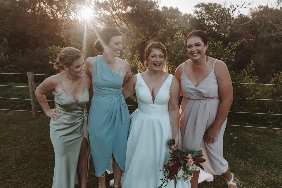 A bride and her bridesmaids are posing for a picture together. — Vanity Skin and Beauty Forster in Forster, NSW