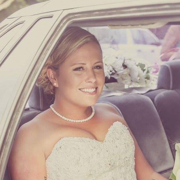 A woman in a wedding dress is sitting in the back seat of a car — Vanity Skin and Beauty Forster in Forster, NSW