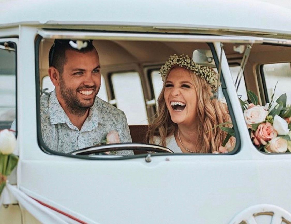 A bride and groom are laughing while sitting in a white van. — Vanity Skin and Beauty Forster in Forster, NSW