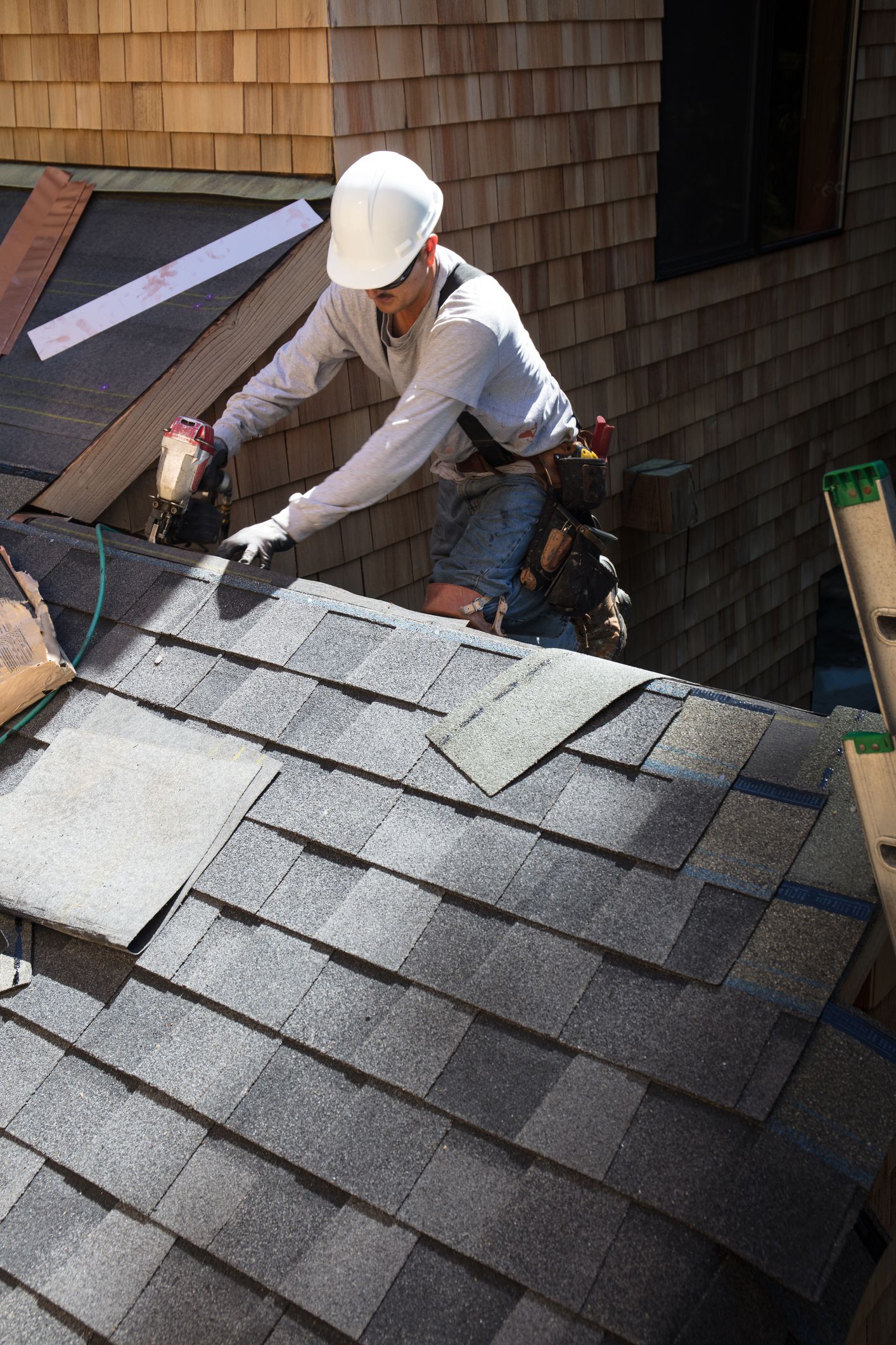 A man is working on the roof of a house.